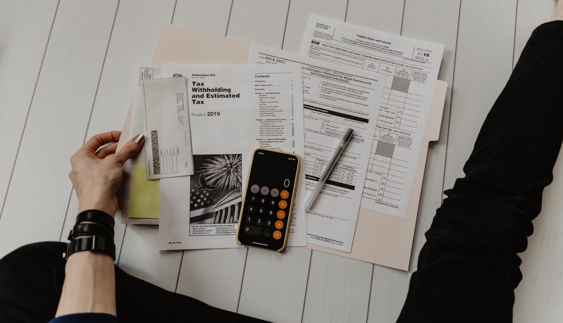 Persona revisando documentos financieros y facturas en una oficina